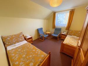 プラハにあるUbytování Kubantoviのベッド2台と椅子2脚が備わる小さな客室です。