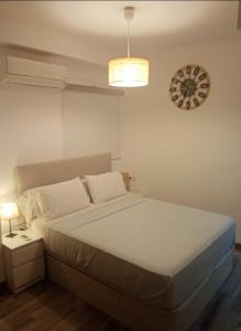 a bedroom with a bed and a clock on the wall at FUENGIROLA PLAYA y PISCINA PERLA 2 ESTUDIO in Fuengirola +10 photos