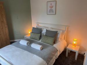 a bedroom with a large white bed with two lamps at Montrose - Perfect contractor stay, own driveway, 3 bedrooms in Gateshead