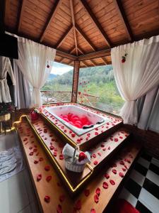 a room with a bath tub with roses on a table at Cabana Dois Amores. Destino romântico. in Barracão