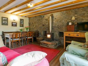 sala de estar con chimenea y comedor con mesa en The Smiddy - S4278, en Lochearnhead
