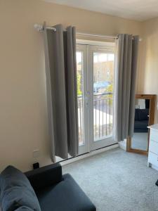 a living room with a sliding glass door at Private Rooms In A Cheerful 4-Bedroom Town House in Broughton