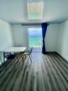 a room with a table and chairs and a view of the ocean at Villas Encanto in Baru
