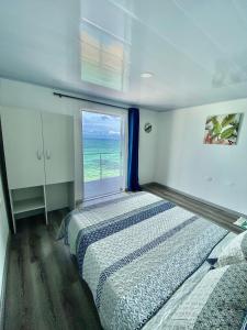 um quarto com uma cama e uma janela com o oceano em Villas Encanto em Barú