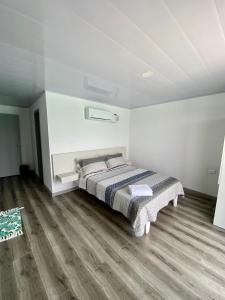 a bedroom with a bed in a white room at Villas Encanto in Baru