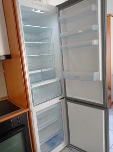 - un réfrigérateur vide avec des portes ouvertes dans la cuisine dans l'établissement Vassilikos Apartment, à Flogita