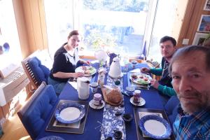 a group of people sitting around a table with food at Risør Bed & Breakfast, Randvik Strand in Risør +13 photos