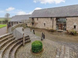 a stone building with a staircase in front of it at Self-Catering at Craft Renaissance in Usk