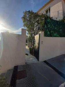 a white fence with a gate in front of a house at Appartement climatisé au calme en Provence in Pierrefeu-du-Var