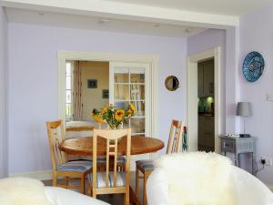 a dining room with a table with flowers on it at Seashore Apartment in Sandgate