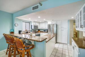 a kitchen with blue walls and wooden bar stools at Arie Dam 304 in St. Pete Beach