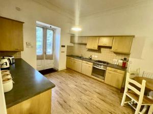 a kitchen with wooden floors and a counter top at Serviced Accommodation Moray - Lesmurdie House No 2 in Elgin +2 photos