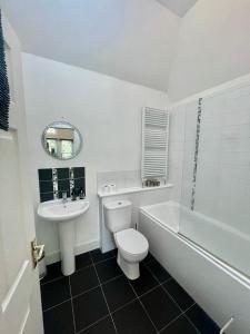 a white bathroom with a toilet and a sink at Serviced Accommodation Moray - Lesmurdie House No 2 in Elgin