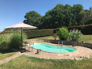 a small pool with an umbrella and a table and chairs at Botanica in San Sisto