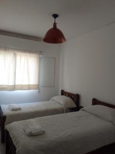 - une chambre avec 2 lits et une fenêtre lumineuse dans l'établissement Plaza España, à Mendoza