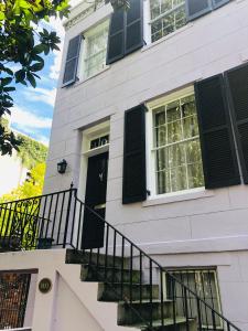 una casa blanca con persianas negras y una puerta negra en Savannah Sojourn - Time Travelers Retreat 1853 en Savannah