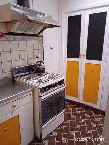 uma cozinha com um fogão e uma chaleira. em Villa Lidia em Mar del Plata