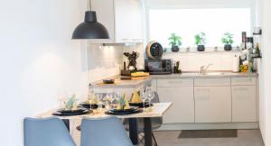 a kitchen with a table and chairs and a sink at Customflats - Tiefgarage - Terrasse - Uninähe in Ulm