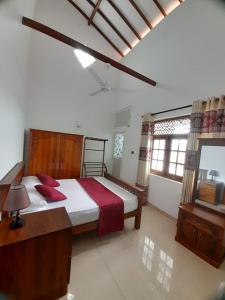 sypialnia z dużym łóżkiem z czerwonymi poduszkami w obiekcie Jasmine Apartments w Negombo