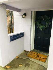 a front door of a house with a sign on it at Savannah Sojourn - Time Travelers Retreat 1853 in Savannah