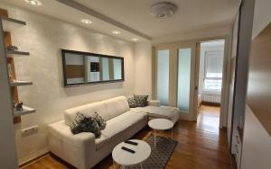 a living room with a white couch and a mirror at Belville City apartment in Belgrade