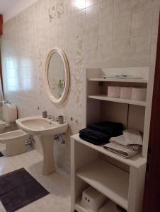 a white bathroom with a sink and a mirror at Il Faggio in Beura