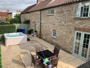 a backyard with a hot tub and a house at Farriers Cottage in Lincoln