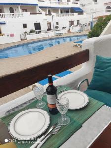 a table with plates and a bottle of wine and glasses at Blue Island House on the hill in Los Cristianos