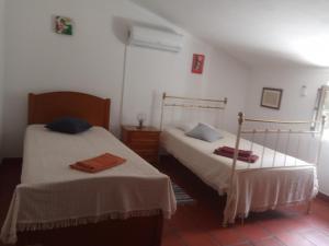 two beds in a room with white walls at Monte da Samarra - Alojamento Local in Avis