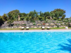 una piscina con 2 sillas junto a la aficiencia en Villa delle Palme en Acitrezza