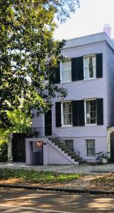 a white building with a staircase in front of it at Savannah Sojourn - Time Travelers Retreat 1853 in Savannah