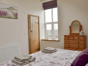 sypialnia z łóżkiem, lustrem i komodą w obiekcie Besss Cottage w mieście Middlewich