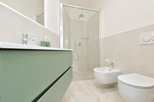 a white bathroom with a toilet and a sink at Milleventi Apartments in Bologna