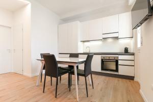 Milleventi Apartments في بولونيا: مطبخ مع طاولة وكراسي في غرفة