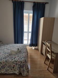 1 dormitorio con cama, escritorio y ventana en Hostal Fantoni, en Cádiz