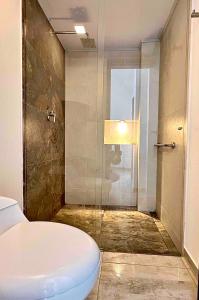 a bathroom with a toilet and a glass shower at La Vista EcoHouse in Macanal