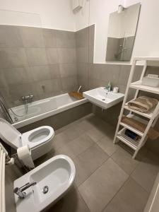 uma casa de banho com um lavatório, um WC e uma banheira em Apartment Milano Via Roncaglia em Milão