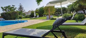aption to a pool with an umbrella and a swing at Viena Rooms & Apartments in Palaiochóra