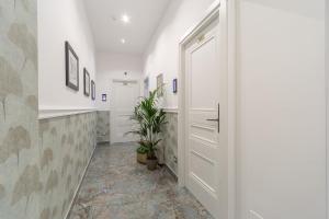un corridoio con una porta bianca e una pianta di Duomo Smart Suites a Milano
