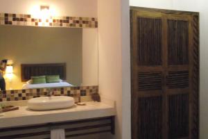 y baño con lavabo y espejo. en Casa Mandala Hotel, en Pijijiapan