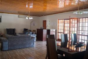 salon z 2 kanapami i stołem w obiekcie Haithoms Guesthouse w mieście Gaborone