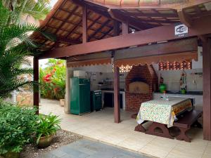 an outdoor kitchen with a table in a pavilion at Itaúna Hostel in Saquarema