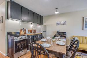 a kitchen with a table and chairs and a kitchen with a stove at Creekside Condo 136 - Meredith Lodging in Neskowin