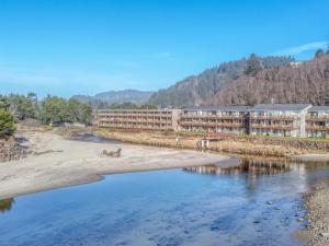 a hotel on the shore of a body of water at Creekside Condo 136 - Meredith Lodging in Neskowin +16 photos