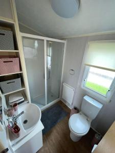 a small bathroom with a toilet and a sink at Robin hood Caravan park North Wales Free Wi-Fi and Smart TVs Passes not included in Rhyl