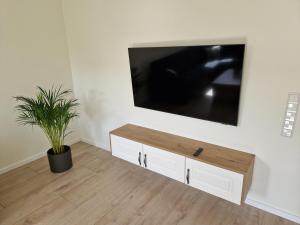 a living room with a flat screen tv on a wall at Apartment nahe Meyer Werft in Ostfriesland mit Küche & Netflix in Westoverledingen