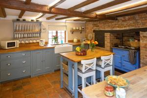 a kitchen with blue cabinets and a wooden table at Vine Cottage 
