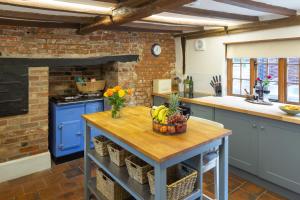 a kitchen with a table with a bowl of fruit on it at Vine Cottage 