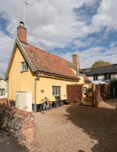 a yellow house with bikes parked outside of it at Vine Cottage 