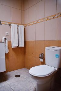 a bathroom with a toilet and towels on the wall at Bungalow Guayana in Mogán